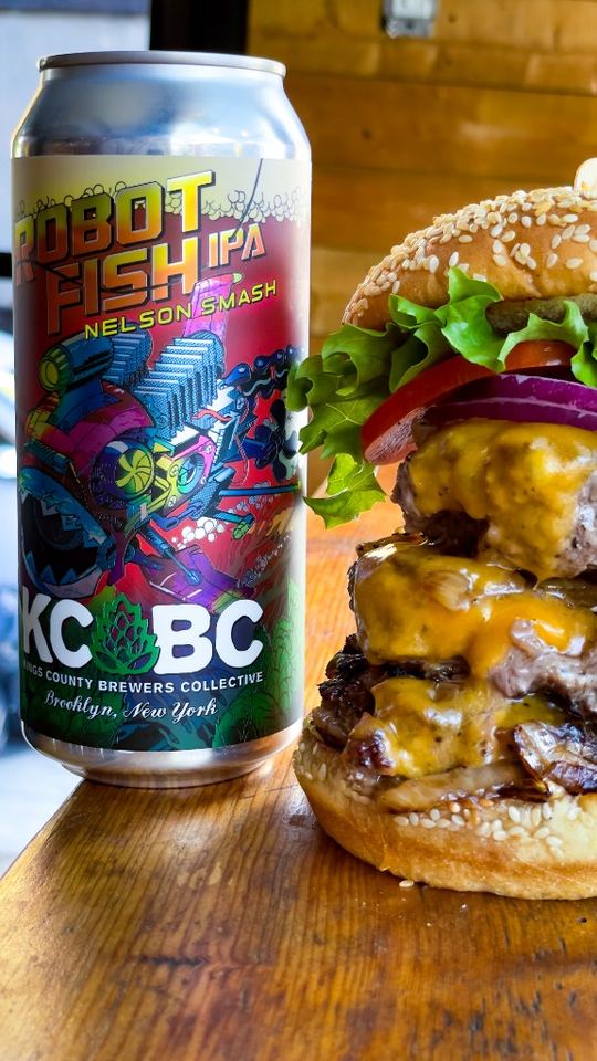 Stacked cheeseburger and cold craft can ready to serve.