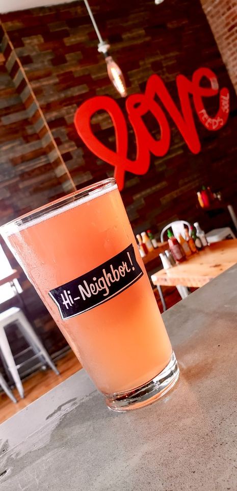 House pink drink served in-store with Love wall backdrop.